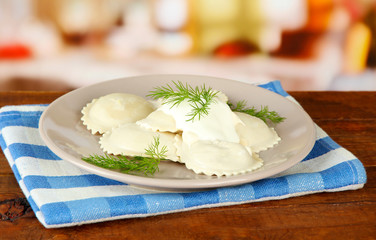 Tasty dumplings on plate, on wooden table