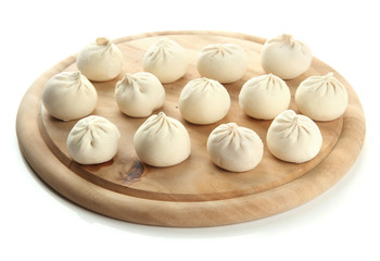 Raw khinkali on wooden desk, isolated on white