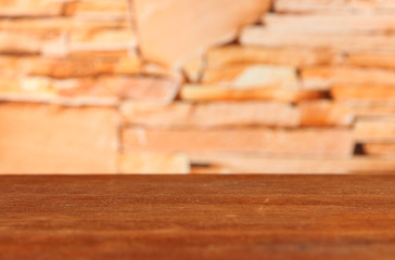 Wooden table on bricks background