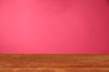 Wooden table on pink background