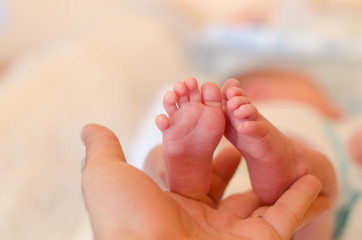 Father is holding his child's foot