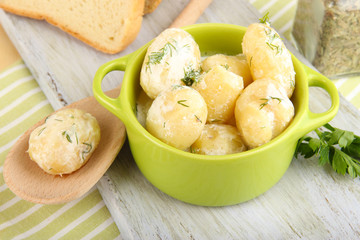 Tender young potatoes with sour cream and herbs in pan