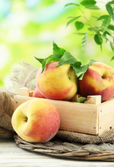 Ripe sweet peaches in wooden crate, outside