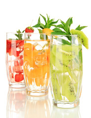 Glasses of fruit drinks with ice cubes isolated on white