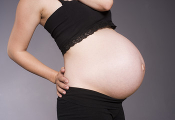 Pregnant Woman Torso Standing Bending Black Gray Background