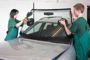 Glazier replacing windshield