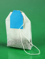 Tea bag on green background