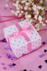 Flowers and gift box on pink background