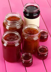 Tasty jam in banks on table