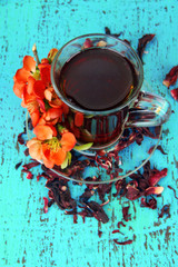 Herbal tea in glass cup, on color wooden background