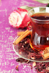 Herbal tea in glass cup, on color wooden background