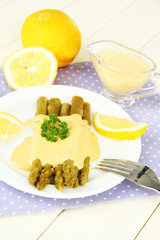 Asparagus on plate, on wooden background