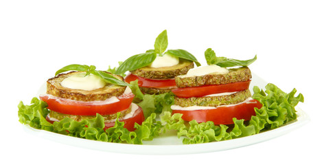 Tasty roasted marrow and tomato slices with salad leaves,