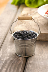 Fototapeta na wymiar Blackberries in silver bucket on wooden rustic table