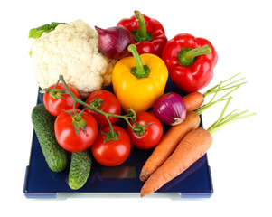 Fresh vegetables on scales on grey background