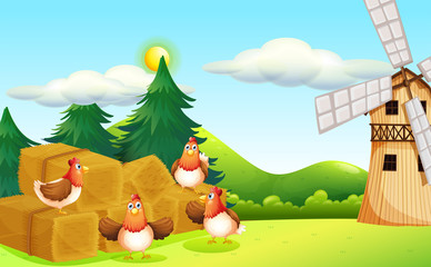 Four chickens at the hay with a windmill
