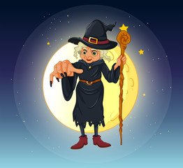 A witch holding a stick standing at the center of a full moon