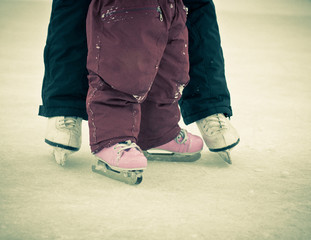 Fototapeta premium Child and parent feet on skates