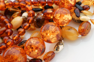 Amber Jewelry with beads necklaces and bracelets close up. Semi precious gemstones on white with...