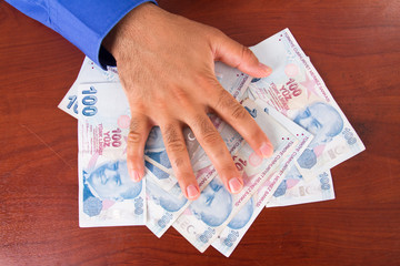Hand on Stack of Banknotes