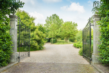 Fototapeta premium Opened black wrought iron gate of a large estate
