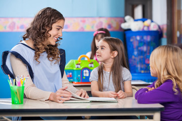 Teacher Teaching Little Girls In Classroom