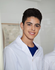 Fototapeta na wymiar Teenage Schoolboy Wearing Labcoat In Science Lab