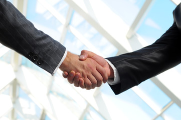 Business man giving a handshake to close the deal