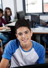 Fototapeta premium Happy Teenage Schoolgirl Sitting In Computer Lab