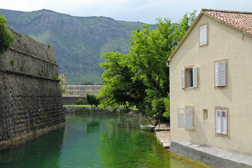 Fototapeta na wymiar house with shuttered windows, river and mountains in Kotor