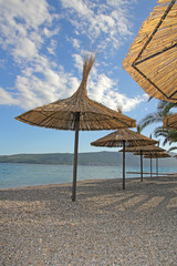 straw sunshades over cloudy sky