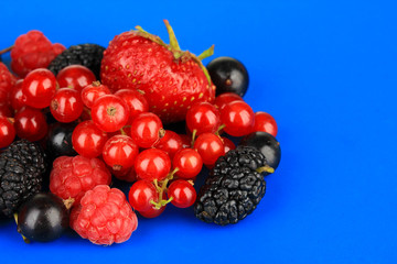 Ripe berries on blue background