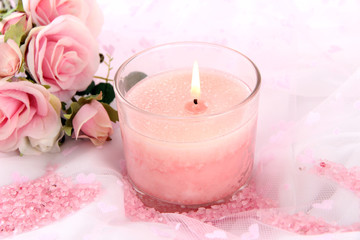 Obraz na płótnie Canvas Beautiful candle with flowers on white cloth, close up