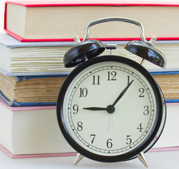 alarm clock on books background