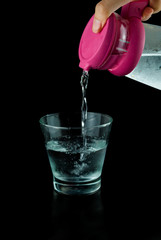 Pour water from a pitcher into a glass