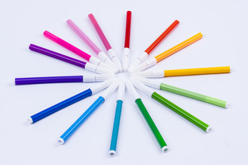 Colourful markers on white background.