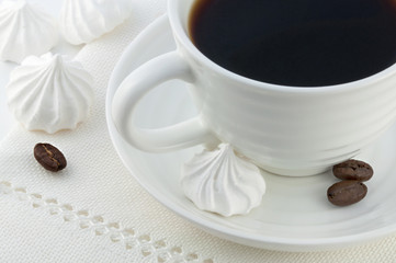 cup of black coffee, beans of coffea arabica and meringue cakes