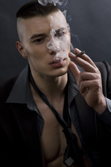 A portrait of a young man smoking a cigarette
