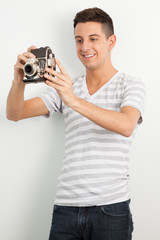 Young man using an old camera
