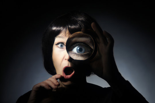 Woman with magnifying glass surprised