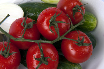 vegetables sprinkled with water lying on a plate: tomato, cucumb