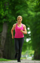 Active female runner in sportswear jogging in the park