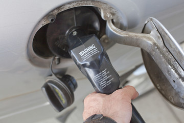 A gas pump inserted into a vehicle fuel tank opening