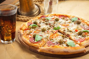 Sailor's pizza next to cold beverage