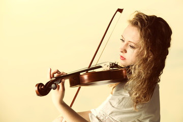 The blonde girl with a violin outdoor