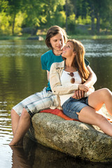 Fototapeta na wymiar Smiling couple sitting on a rock romantic