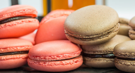 A group of chocolate and pink French macarons and a mug of tea