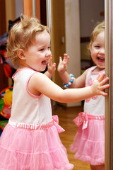 Little girl looking in the mirror