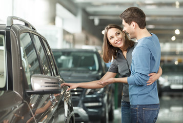 It is the one car I want! Beautiful young couple standing at the