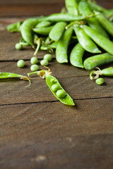 handful of green peas on wooden boards